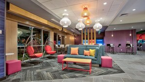 A modern lounge area with a sofa, hanging chairs, and a coffee table. - Home2 Suites by Hilton Wichita Falls, TX (Wichita Falls)