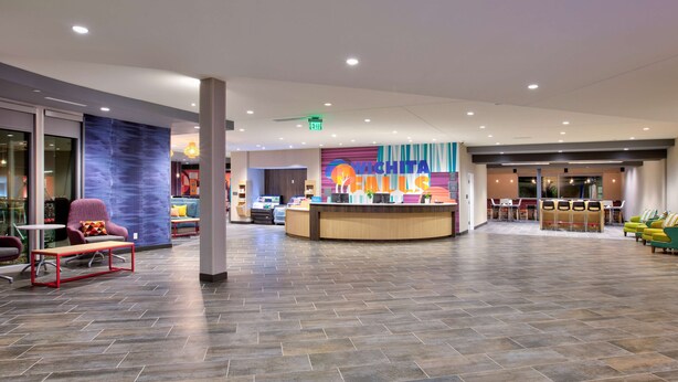 A spacious lobby with a reception desk, seating area, and a colorful wall with the text "WICHITA FALLS". - Home2 Suites by Hilton Wichita Falls, TX (Wichita Falls)