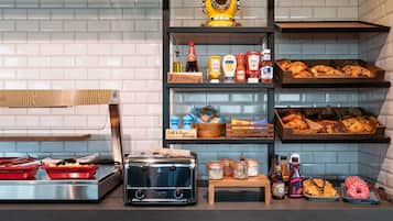 A kitchen counter with a toaster, red cooking pots, and various condiments.