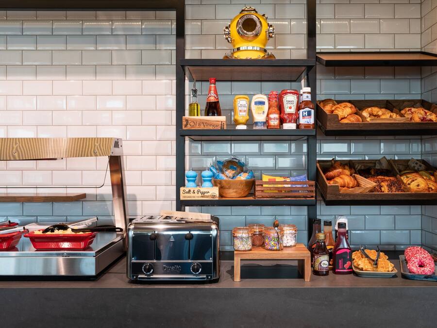 A kitchen counter with a toaster, red cooking pots, and various condiments.