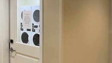 Una puerta con un letrero que dice "GUEST LAUNDRY" y un aviso sobre ropa que queda sin atender.