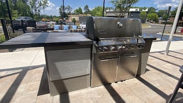 Een buitenbarbecue met een bord waarop veiligheidsvoorschriften staan.
