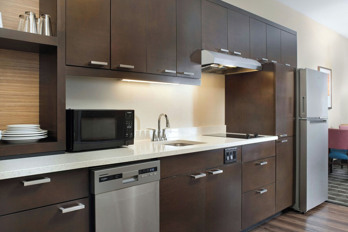 A modern kitchen with stainless steel appliances, a dishwasher, and a microwave.