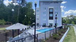 A hotel with outdoor pool, lounge chairs, and umbrellas. - TownePlace Suites Columbia West/Lexington (West Columbia)