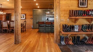 Un intérieur en bois comprenant un coin repas, une cuisine et un présentoir à chaussures.
