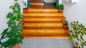 A staircase with wooden steps, green columns, and potted plants. - Great Location & Family Apartment (Lisbon)