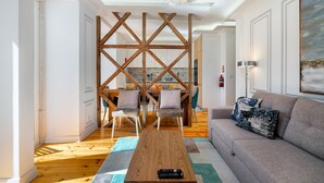A modern living room with a wooden coffee table, grey sofa, and a decorative wall piece. - Great Location & Family Apartment (Lisbon)