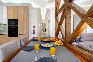 Un espace repas moderne avec une table en bois, des chaises et une vue sur le salon.