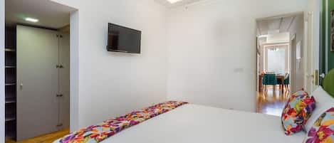 Un dormitorio con cama, televisor y armario.