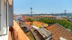 A high vantage point view of a cityscape with a prominent bridge in the background. - Premium River View Apartment (Lisbon)