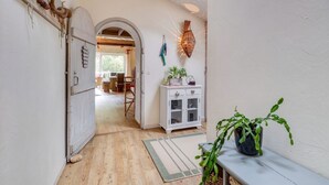 A hallway with a wooden floor, white walls, a white cabinet with glass doors, and a potted plant. - Le Moulin de Pilet 4* - Proche Puy du Fou (Mortagne-sur-Sèvre)