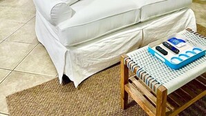A neatly arranged bedroom with a bed, bedside tables, a lamp, and a window with blinds.
