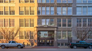 Un edificio de varios pisos con una entrada destacada que dice "SNEAD MANUFACTURING BLDG."
