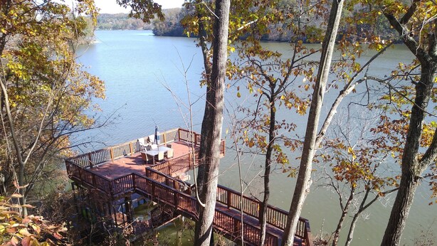 A lakeside wooden deck with outdoor seating and a view of the lake. - Claytor Lake Hideaway (Pulaski)