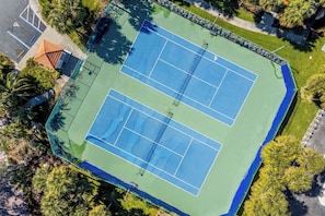 An aerial view of a tennis court complex with two courts, surrounded by trees and a small building. - Escape 2 Lands End Your Beachside Paradise on T.I. (Treasure Island)
