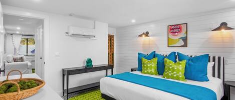 Un dormitorio moderno con una cama grande, una mesita de noche y aire acondicionado instalado en la pared.