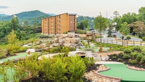 A golf course with a large building in the background.