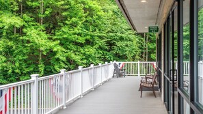 A covered outdoor area with a white railing, benches, and a sign indicating a fitness center.