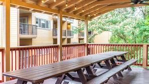 A covered outdoor area with a picnic table and red railings.