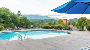 Ein Swimmingpool mit Liegestühlen und Blick auf Berge.