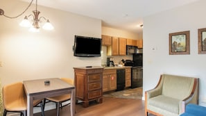 A compact living space with a dining area, kitchenette, and a seating area.