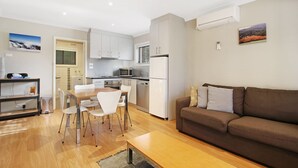 A modern apartment with a kitchen, dining area, and living room.