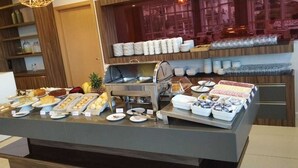 Ein reichhaltiges Buffet mit verschiedenen Speisen und einer Selbstbedienungsgetränkestation.
