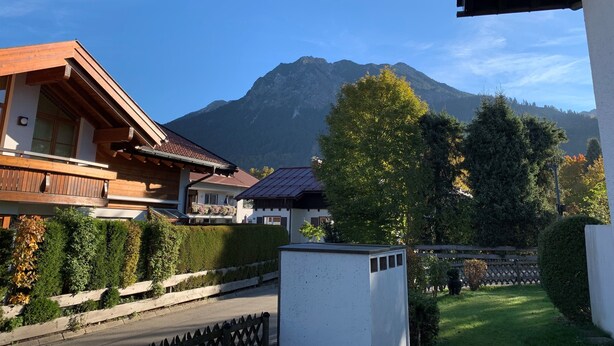 Une vue sur une montagne, avec une maison en bois et un bâtiment blanc au premier plan.
