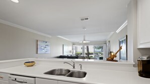 Una cucina moderna con un lavello doppio, mobili bianchi e lavastoviglie.