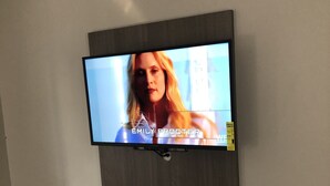 A flat-screen TV mounted on a wall with a visible price tag of $10. - Trolley Stop Motel (Media)