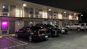 A multi-story hotel with a parking lot. - Trolley Stop Motel (Media)