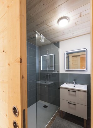 A modern bathroom with a glass-enclosed shower, a white sink, and a mirror with a lighted frame. - Veliski-Lodge, a chalet for rent in Haute-Maurienne (Modane)