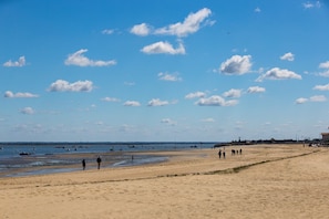A wide sandy beach with a clear sky and scattered clouds. - Cozy studio, close to the beach, with a real bed and parking (Arcachon)