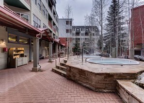 A hotel courtyard with a pool, stone steps, and a brick pathway.