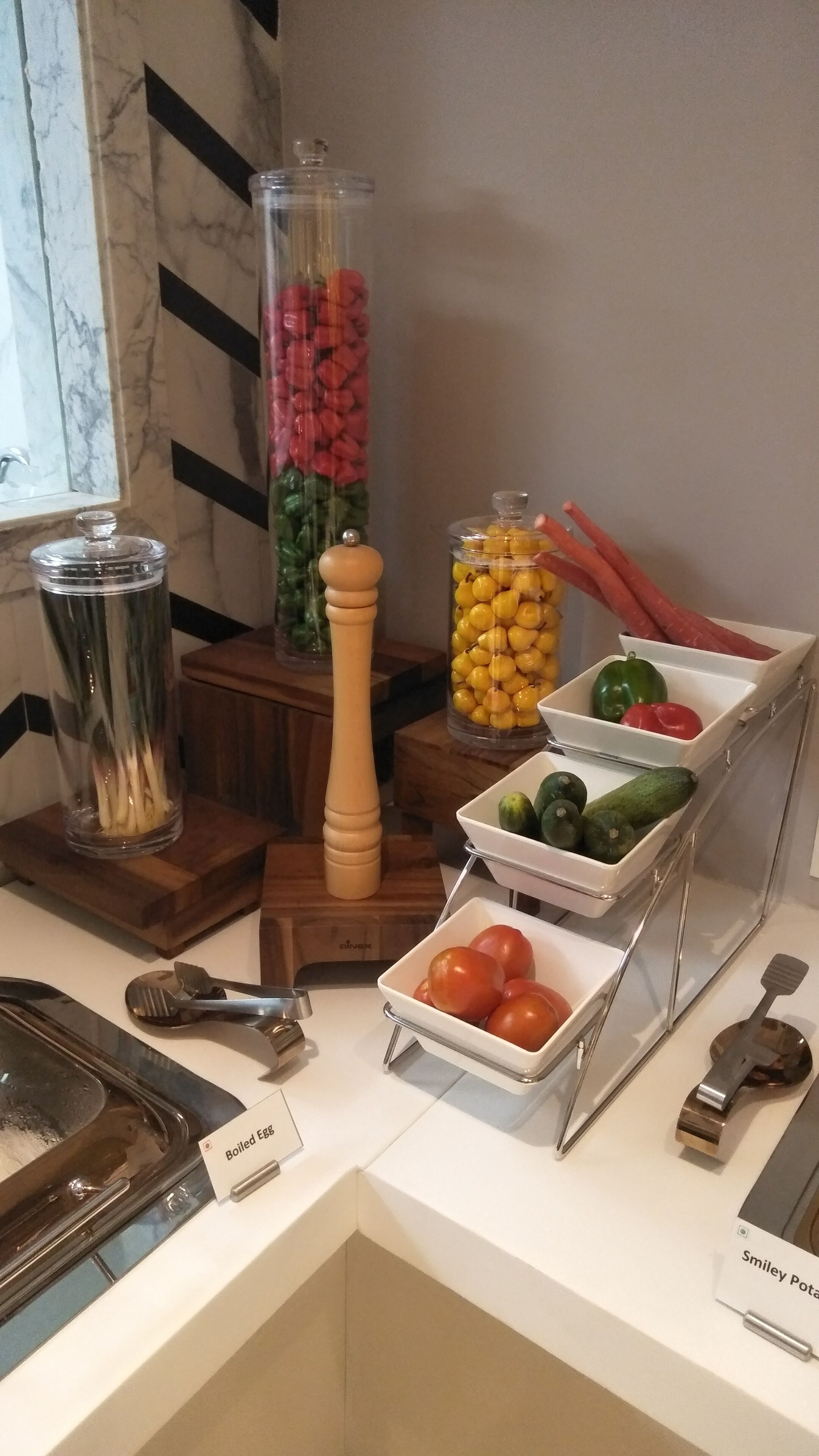 Un buffet proposant une variété d’aliments, notamment des œufs durs, des tomates, des concombres et des poivrons.