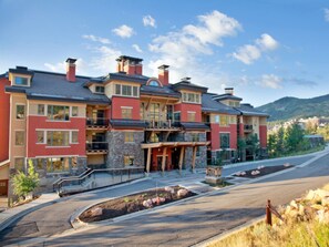 Stunning mountain views surround this modern residential building with balconies and beautifully landscaped grounds.