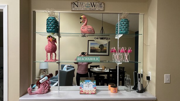 A kitchen counter with a decorative sign reading "BEACHAHOLIC" and a framed picture of a beach scene. - Pet Friendly Townhome Between Ocean Isle and Sunset Beach (Ocean Isle Beach)