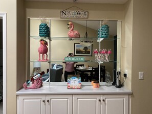 Una encimera de cocina con un letrero decorativo que dice "BEACHAHOLIC" y una foto enmarcada de una playa.