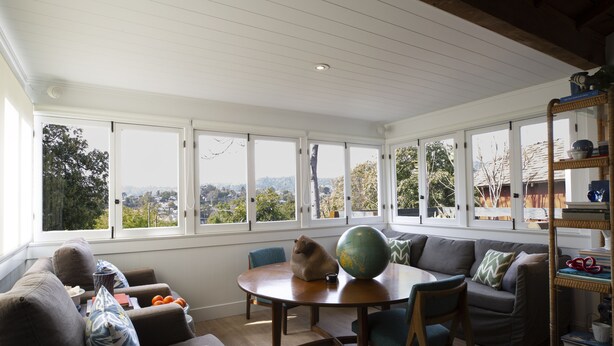 A cozy living room with a round wooden table, a globe, and a bookshelf. - Peaceful Hillside Garden Cottage (Los Angeles)
