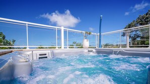 Un jacuzzi con vista despejada al cielo y follaje circundante.