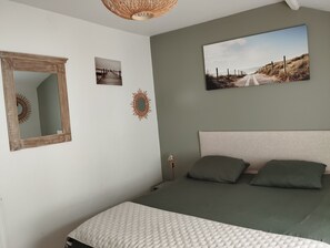 Makuuhuoneessa on sänky, peili, kaksi seinälle ripustettua taulua ja seinävalaisin.