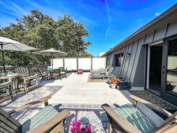 An outdoor patio area with seating, tables, and umbrellas.