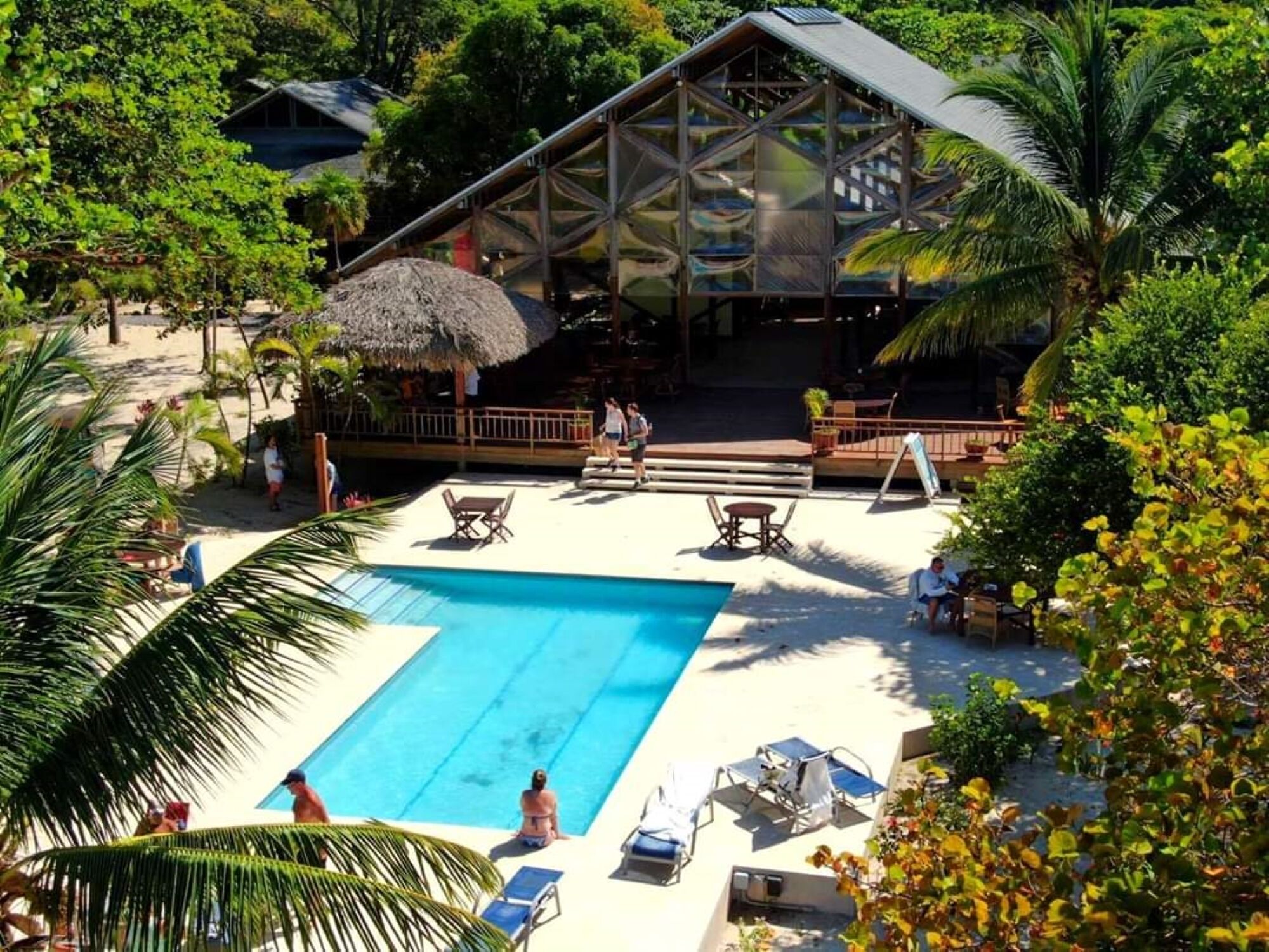 A pool area with lounge chairs and a covered seating area.