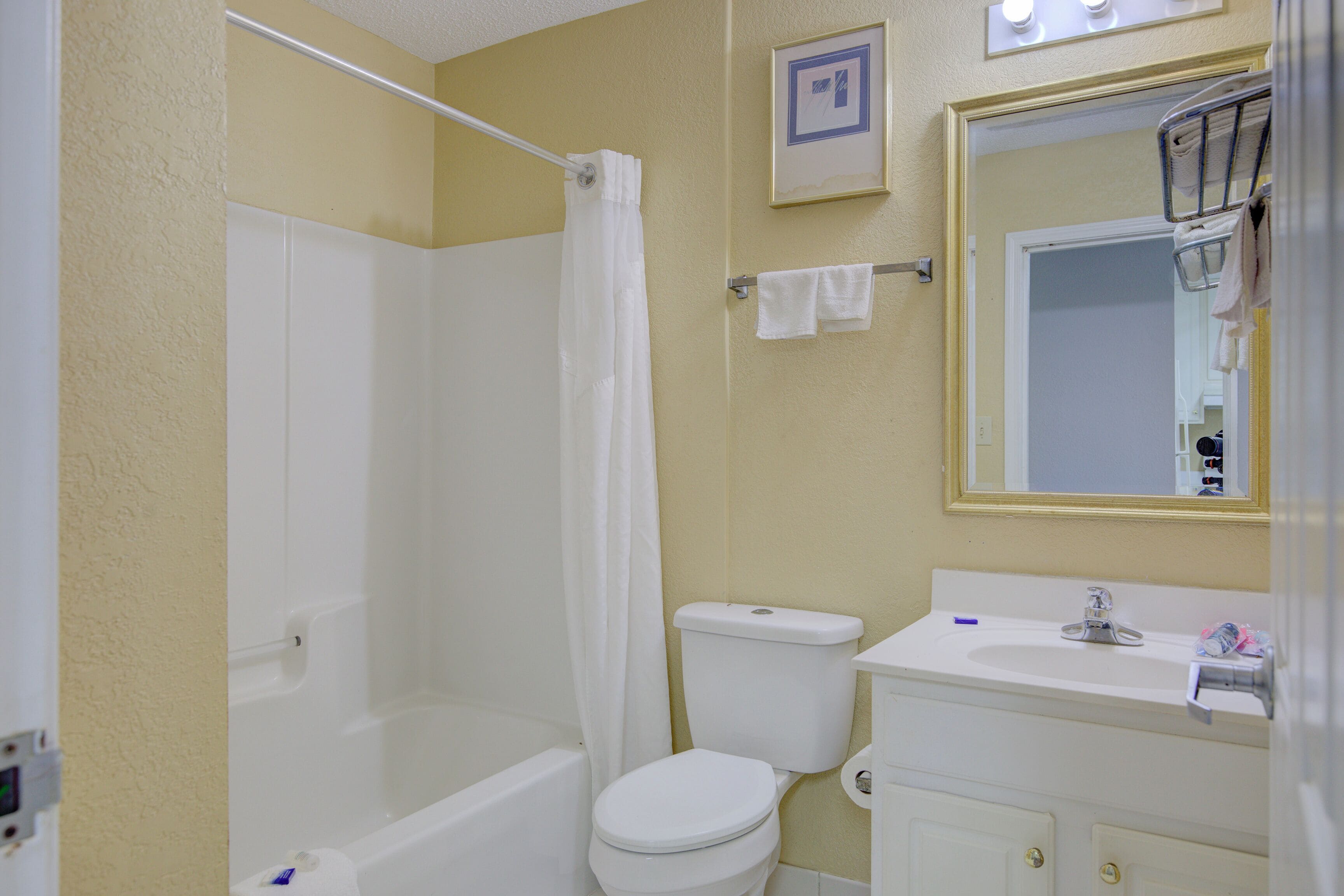 Un bagno con vasca, servizi igienici, lavandino e specchio.