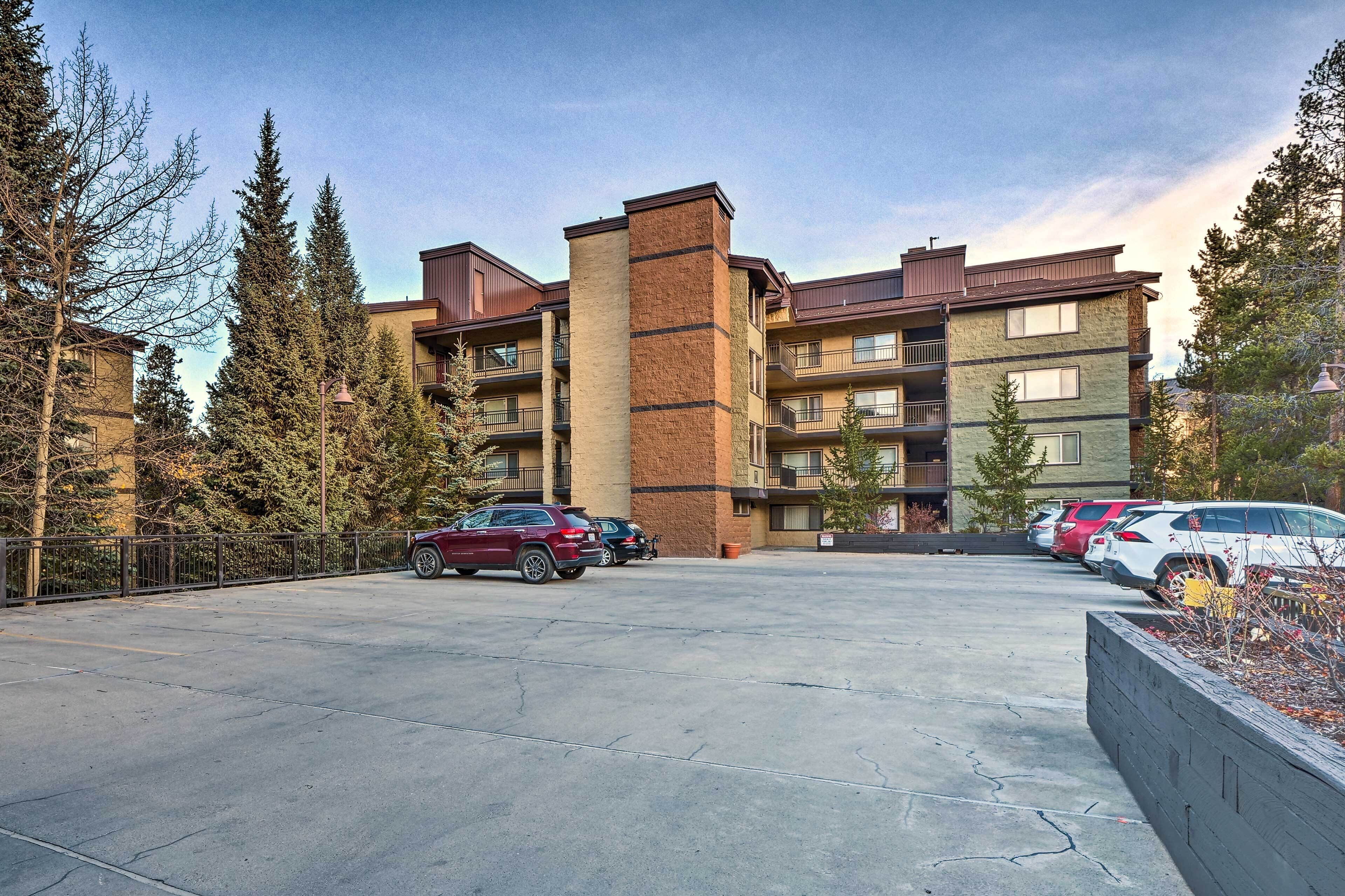 A multi-story residential building with a parking lot in front.