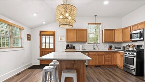 Une cuisine moderne avec des meubles en bois, un îlot central et des appareils électroménagers en acier inoxydable.