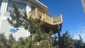 Un edificio con terraza de madera y un letrero que dice 'AIA Resort Village'.