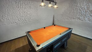 Une table de billard avec un luminaire placé au-dessus.