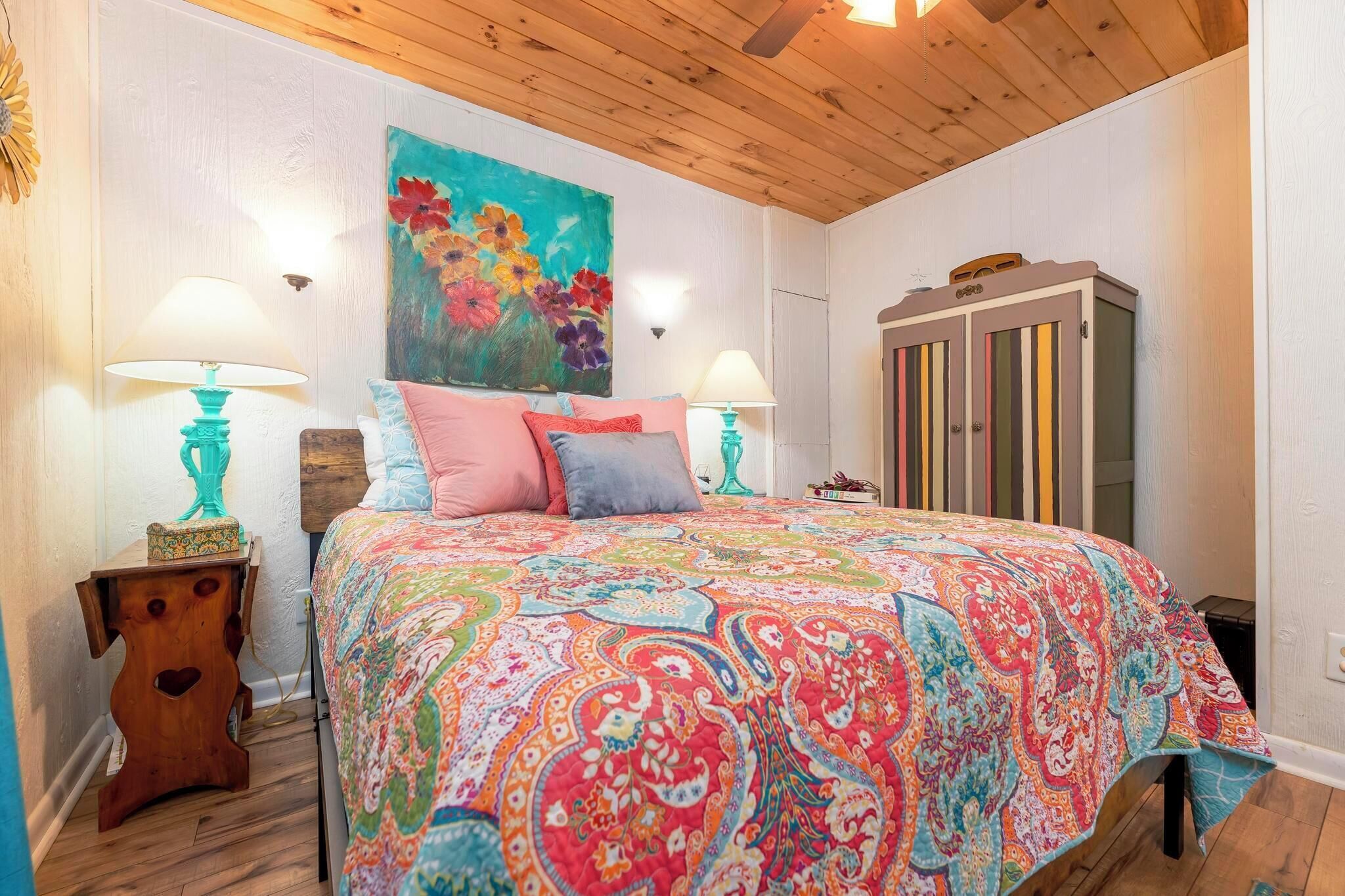 Primary private bedroom with queen bed.  There is also a record player and fan. 