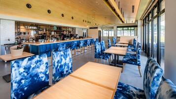 A modern bar with seating and a kitchen area.
